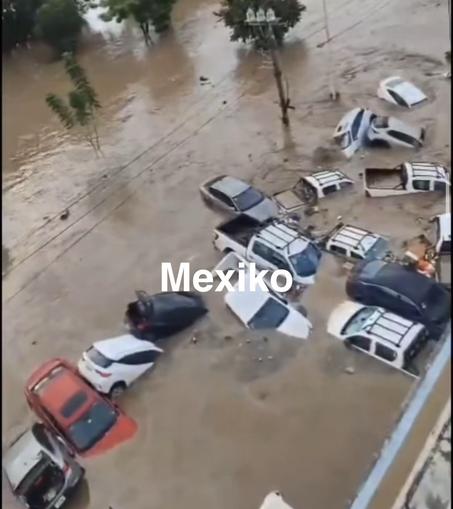 Straße in Mexiko, Fluten reißen Autos mit.