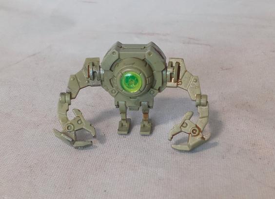 A tiny green mecha with a big sensor eye, and big clawed arms. It is vaguely adorable.