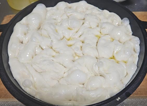 a photo of a oiled focaccia dough ready for the oven