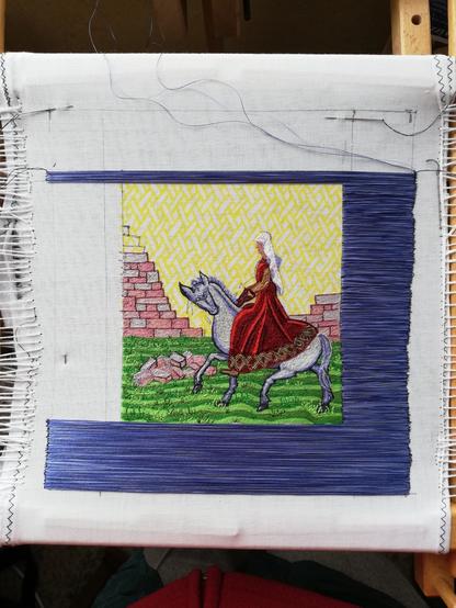 View of the embroidery in progress. The blue border now goes across the bottom and up the right side, and I have started on the top border.