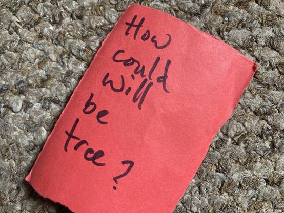 Small red card with ‘how could will be free?’ handwritten on it