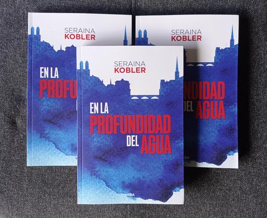 Fotografía en color de tres ejemplares de la novela «En la profundidad del agua», por Seraina Kobler