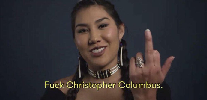 indigenous woman giving the finger and saying fuck christopher columbus