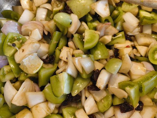 A mixture of roughly chopped apple, green tomato, sultanas, and onion in a jam kettle ready to be transformed into chutney.