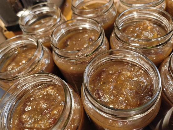 Jars full of green tomato chutney, ready for their lids.