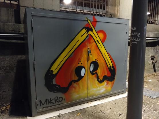 Street art. Upside down heart drawn by two consumed matches in front of a fire. Painted on an outdoors electrical cabinet.