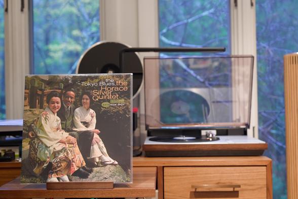 The Horace Silver Quintet - The Tokyo Blues LP cover.

A full-bleed color shot of Horace, surrounded by two Japanese woman, on some stone steps, with woods behind.

The black LP plays on a vintage, restored Bang & Olufsen Beogram 4000 linear-tracking turntable to the right.