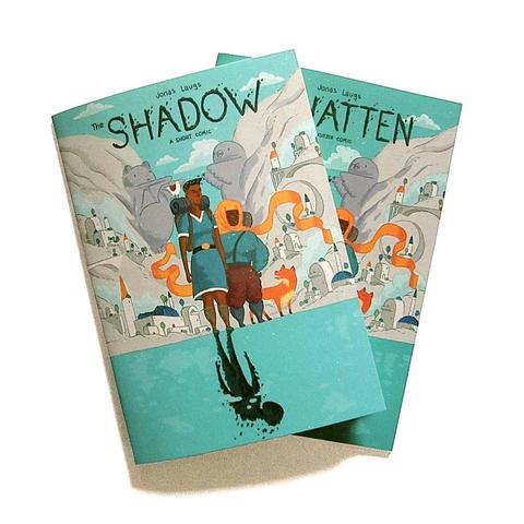 A photo of the printed English and German editions, the cover showing the two main characters in front of a city in a valley. They're standing (on the shore?) of a lake. There's a shadowy creature instead of the reflection of one of the main characters in the water.