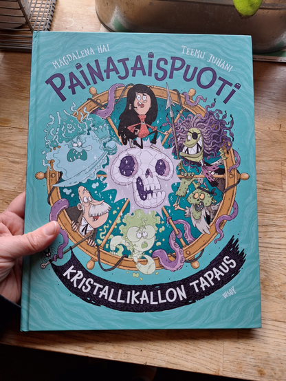 Turkoosi kirja, jonka kannessa kristallikallo, Painajaispuodin väkeä ja monenlaisia hirviömäisiä merirosvoja.