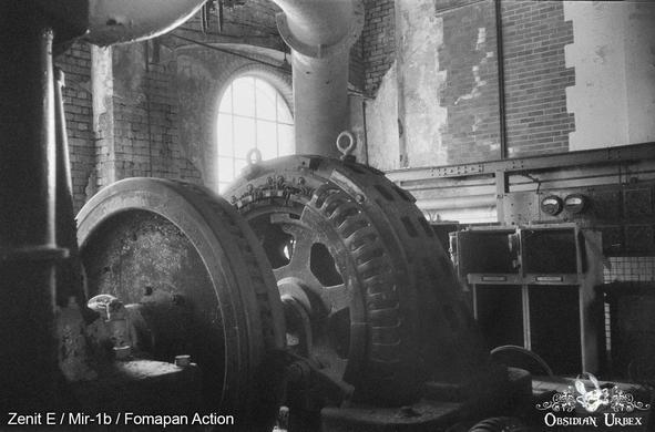 A large industrial machine in an abandoned brick building