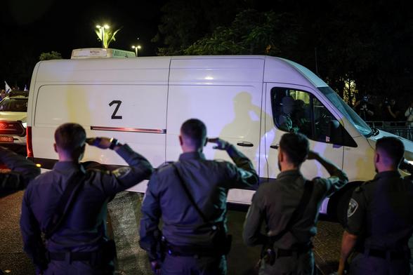 Los vehículos con los cuerpos de cuatro rehenes fallecidos a su llegada al Instituto Forense de Tel Aviv, el lunes.