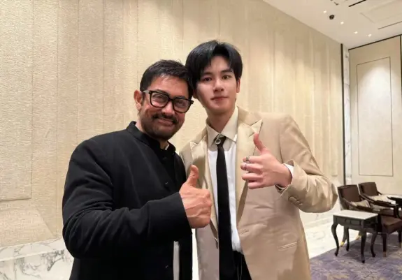 Just a photo of Aamir Khan and Hu Xianxu doing the thumbs up respectively for the photo. AK is in a black Nehru suit and HXX is a tan suit with black tie and trousers.