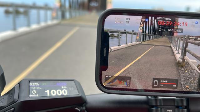 Close up of ebike odometer showing 1000km. On the right is cellphone camera showing William Commanda Bridge.