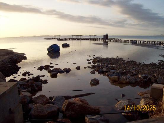 More trash containers in the water, next to a sea walkway