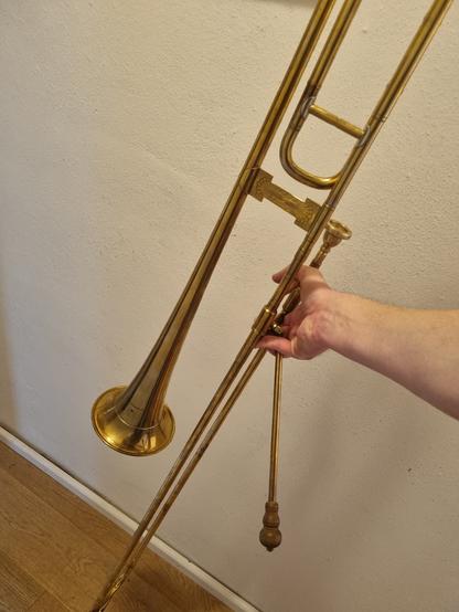 Bild einer messingfarbenen Posaune aus der Renaissance. Der Schallbecher ist wesentlich kleiner, außerdem befindet sich ein Schwengel am Zug.