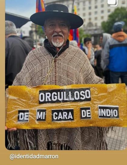 Un señor indígena con ropa campesina sostiene un cartel que dice: orgulloso de mi cara de indio