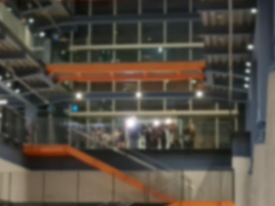 A press scrum taking place on the second floor, with TV camera lights.