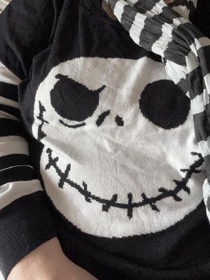 Jack Skellington’s face on a black jumper with black and white stripes on the sleeves and a black and white striped shawl to match!