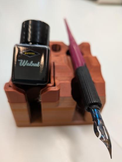 An ink stand, upon which sits a bottle of Walnut ink from one of Diamine's Inkvent calendars, and a dippy pen.