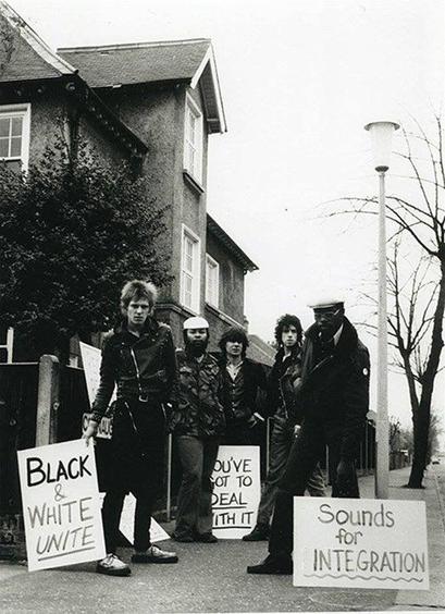 Members of Steel Pulse, The Clash and Sex Pistols demonstrating outside National Front Leader Martin Webster’s house in 1977