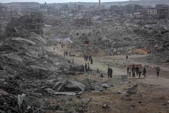 Palestinos regresaban al barrio Al Nafaq, de Ciudad de Gaza, reducido a ruinas por la ofensiva israelí, el pasado domingo.