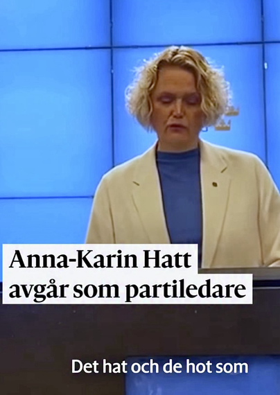 Anna-Karin Hatt på bild, meddelar att hon  avgår som partiledare. Hon står i talarstolen iklädd blå T-shirt & gul kavaj.