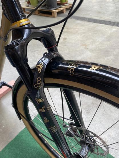 Black and gold step through bicycle with bee decals and brass stars