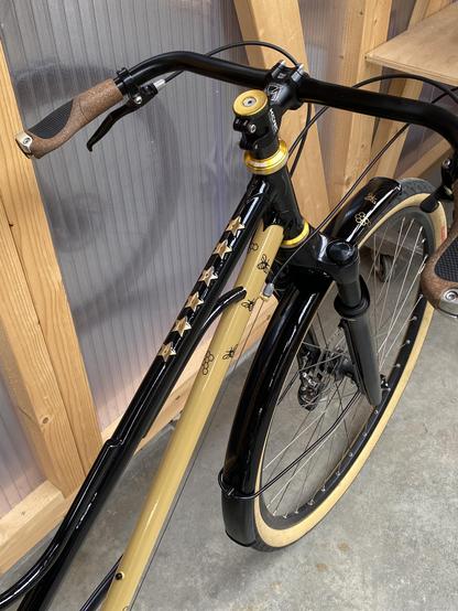 Black and gold step through bicycle with bee decals and brass stars