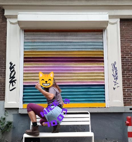 Jemand beim Twerking auf einer Bank vor bunten Rolläden