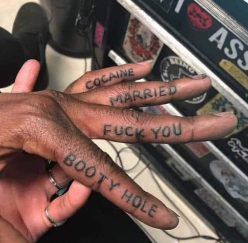 dude’s four fingers fanned out showing a tattoo on each on from pointer to pinky:
booty hole, fuck you, married & cocaine