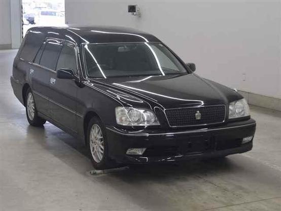A 2000 Toyota Crown Estate wagon hearse. It is jet black with a raised back for loading and unloading of caskets.