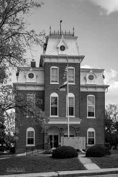 The Dent County, Missouri courthouse is Second Empire architecture , also known as the General Grant Style.  This black and white photo is of the front of the building and includes a flag pole flying the US and Missouri flags and the Dent County Veterans Memorial.