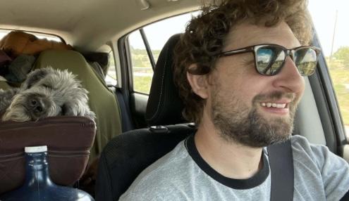 Jiva Manske driving with dog in back seat