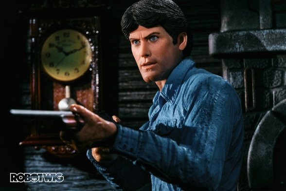 Ash holds a shotgun looking toward the camera in the wooden cabin. A clock hangs on the wall behind him.