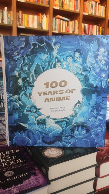 Cover to the coffee table book, 100 Years of Anime, the title in a circle, surrounded by many characters from anime films and TV