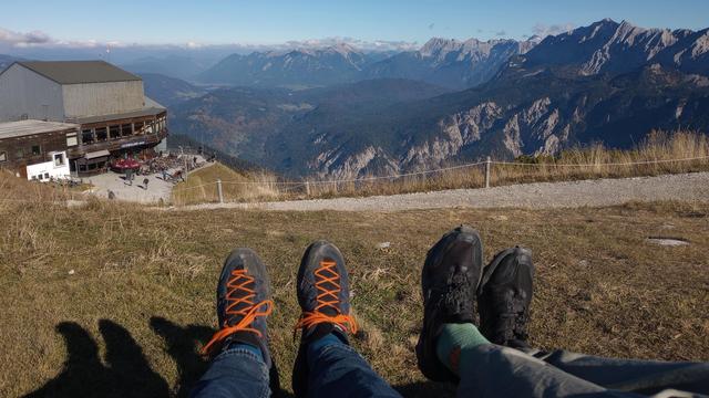 Zwei Paar Wanderschuhe mit Blick auf die Bergstation Alpspitzbahn