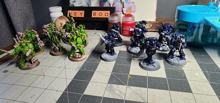 On the left is the Deathguard Kill Team, and the right is the Angels of Death. Deathguard have been zenithal primed with various brown colors while the AoD got the black to light Grey treatment. DG have been painted with a lime green contrast paint (2:1 Striking Scorpion : Bad Moon). AoD was contrasted with Levaidon Blue.