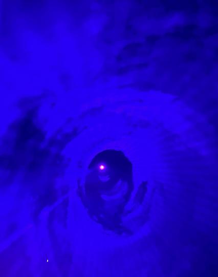 Ein dunkelblauer Tunnel mit einem roten Licht in der Mitte des Ausgangs