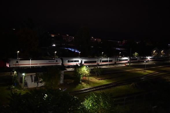 Etwas weitwinkelog auf den Zug beleuchtet vom Gleisfeld.