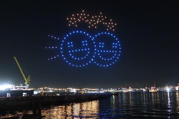 Drones making two smiley faces with stars above them.