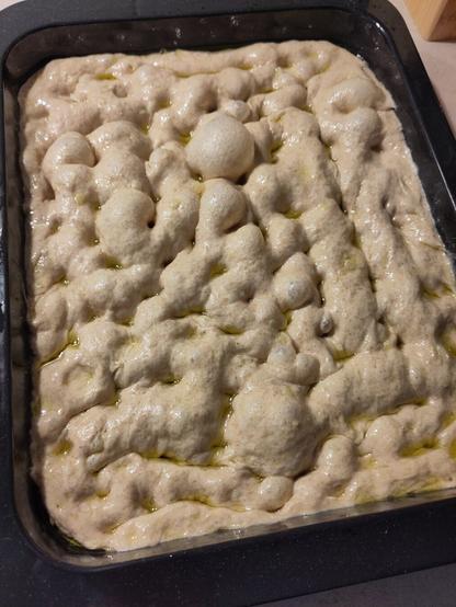 Der Teig in der späteren Backform wurde mit den Fingern eingedrückt, wobei sich Blasen gebildet haben.