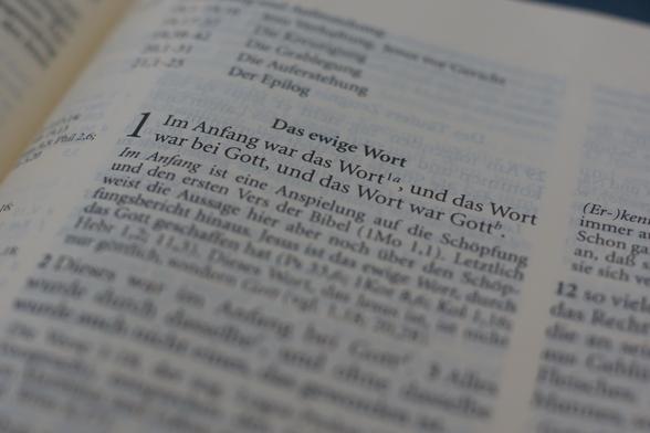 Man sieht den Text des Johannesevangeliums in einer aufgeschlagenen Bibel (ab Kapitel 1).