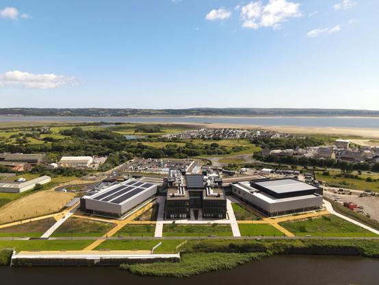Aerial drone image of Pentre Awel wellness village with Llanelli Bay and Machynys coastline visible behind.