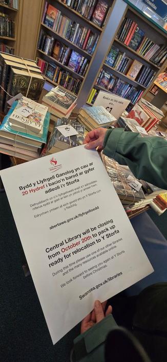 Information poster at Swansea Central Library announcing relocation to Y Storfa community hub.