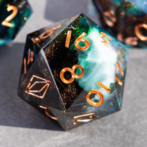 A D20 with peacock feathers and swirls of dark bronze glitter, green and white