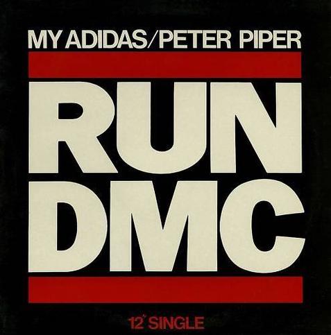 Das Logo der Band Run-D.M.C | Schwarzer Hintergrund, oben und unten ein roter Balken, dazwischen in zwei Zeilen der Schriftzug Run DMC