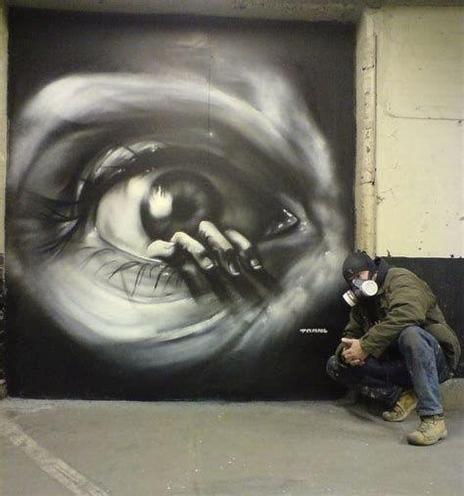 Photo realistic graffiti
It shows an eye and fingers crawling out of it. In front of it the artist .