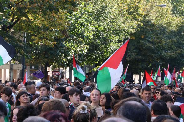 Gran multitud con banderas palestinas; al fondo, árboles