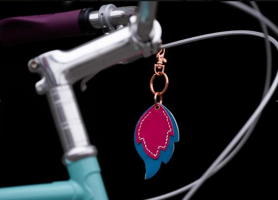 Stem and headtube of mint and purple mini velo with silver components
A trans pride flame keyring hangs from the brake cable