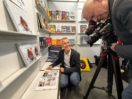 Kameramann filmt Moderator, der meinen Comic durchblättert